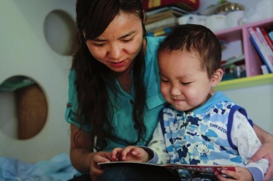 做完家务活，张薇带着图图看漫画书，母子俩沉浸在故事中。组图/潇湘晨报记者陈正