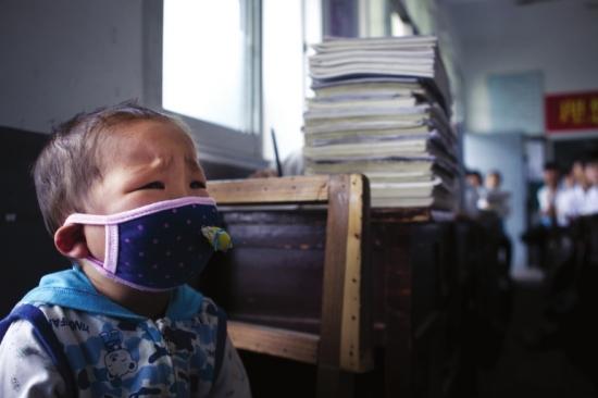 图图一个人坐在教室门边的椅子上，因为有些不舒服，他老是皱着眉头轻声哭泣。 组图/潇湘晨报记者陈正