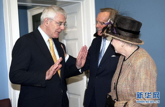 这张2012年2月29日拍摄的资料照片显示，英国前首相约翰·梅杰（左）与女王伊丽莎白二世（右）在伦敦出席活动。梅杰于1990年至1997年任英国首相。新华社/法新