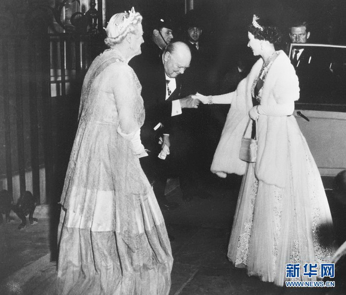 这张1955年4月4日拍摄的资料照片显示时任英国首相温斯顿·丘吉尔（中）在伦敦唐宁街10号举行宴会后亲吻送别伊丽莎白二世（右）。丘吉尔于1940至1945年和1951至1955年任英国首相。新华社/法新